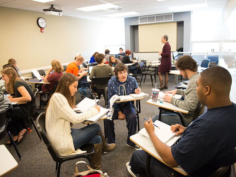 Students in a classroom working on assignments in break-out groups